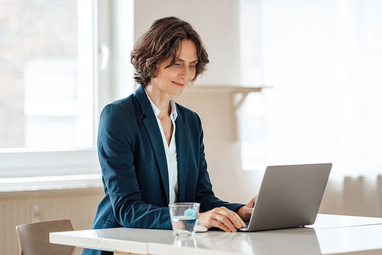 Frau mit Laptop am Schreibtisch