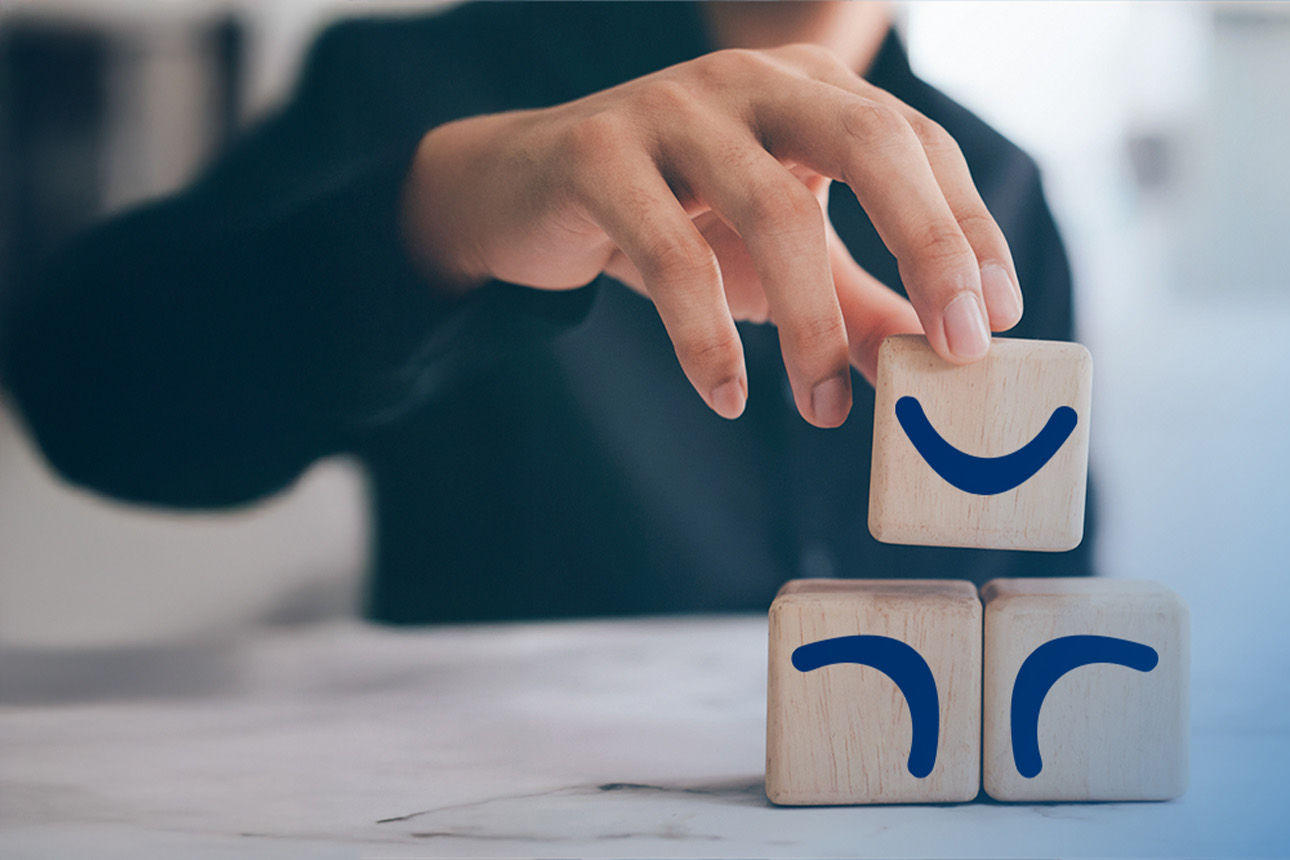 3 Holzklötze mit jeweils einem Boomerrang draur, welche on einer Hand berührt werden