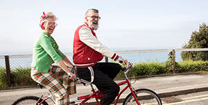 Älteres Paar radelt auf einem Tandem