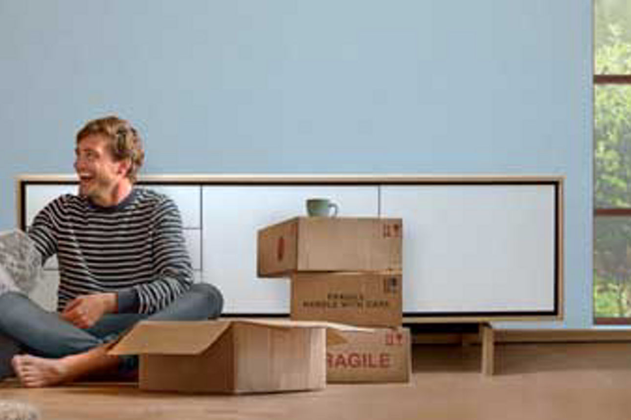 Finanzierungsanfrage - Mann sitzt mit Umzugskartons auf dem Boden
