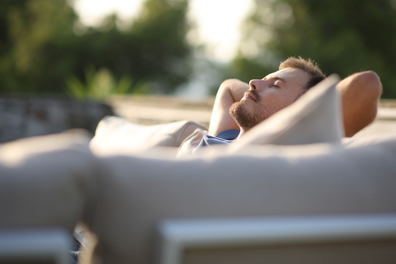 Junger Mann entspannt sich auf seiner Terrasse