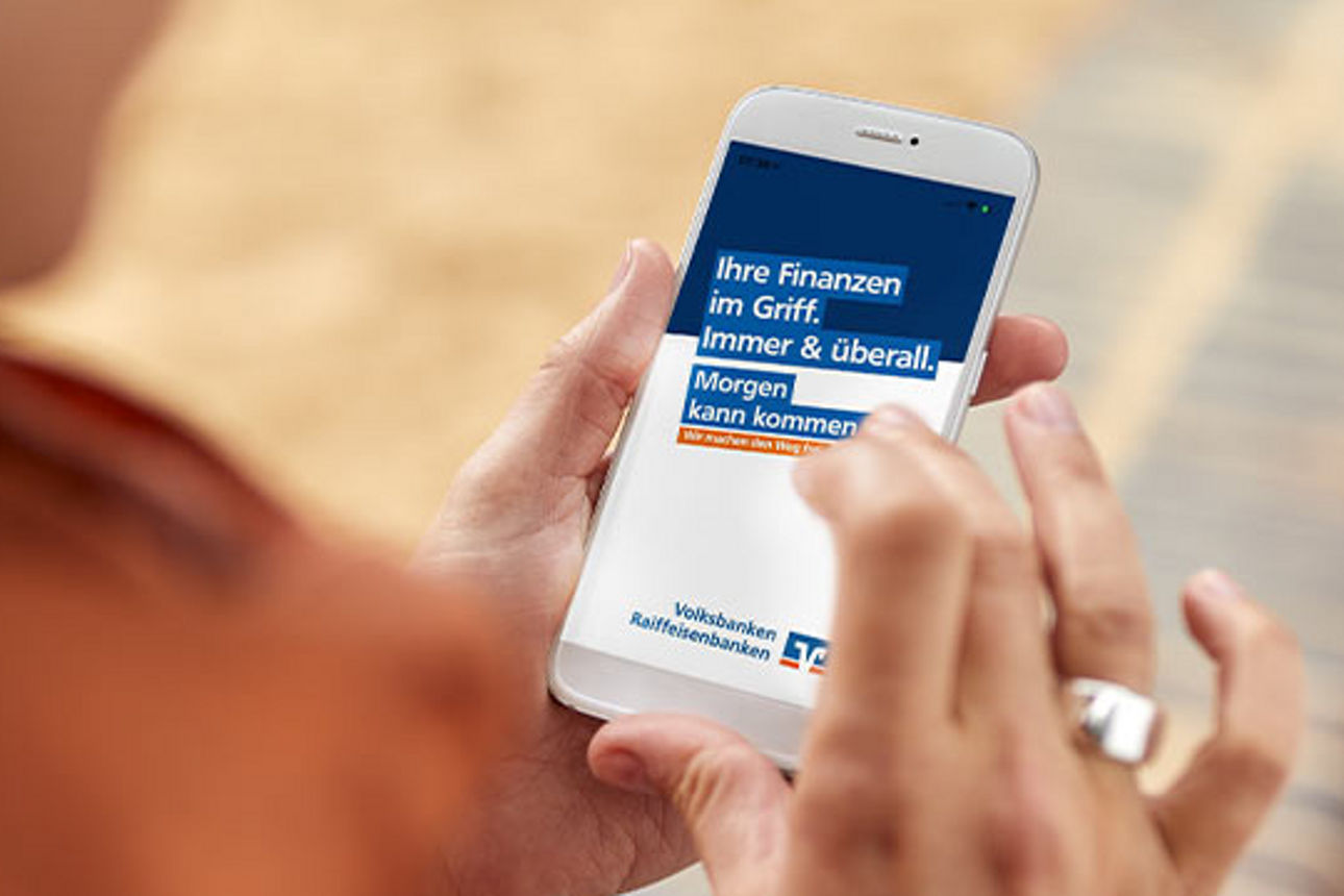 Frau hält Smartphone in der Hand mit der BankingApp