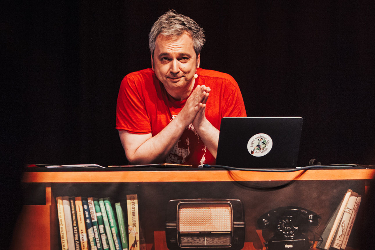 Arnd Zeigler sitzt an einem Schreibtisch - Foto: Max Hartmann