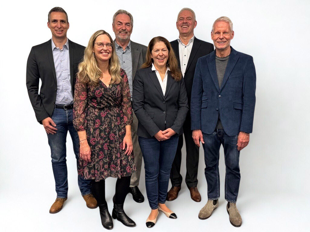 Gruppenbild zwei Frauen und drei Männer stehen vor einem weißen Hintergrund
