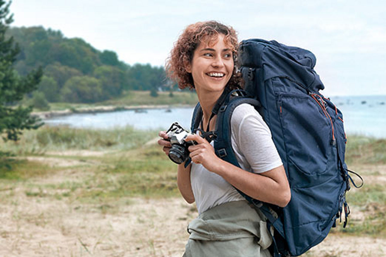 Eine Frau trägt einen Wanderrucksack in der Natur