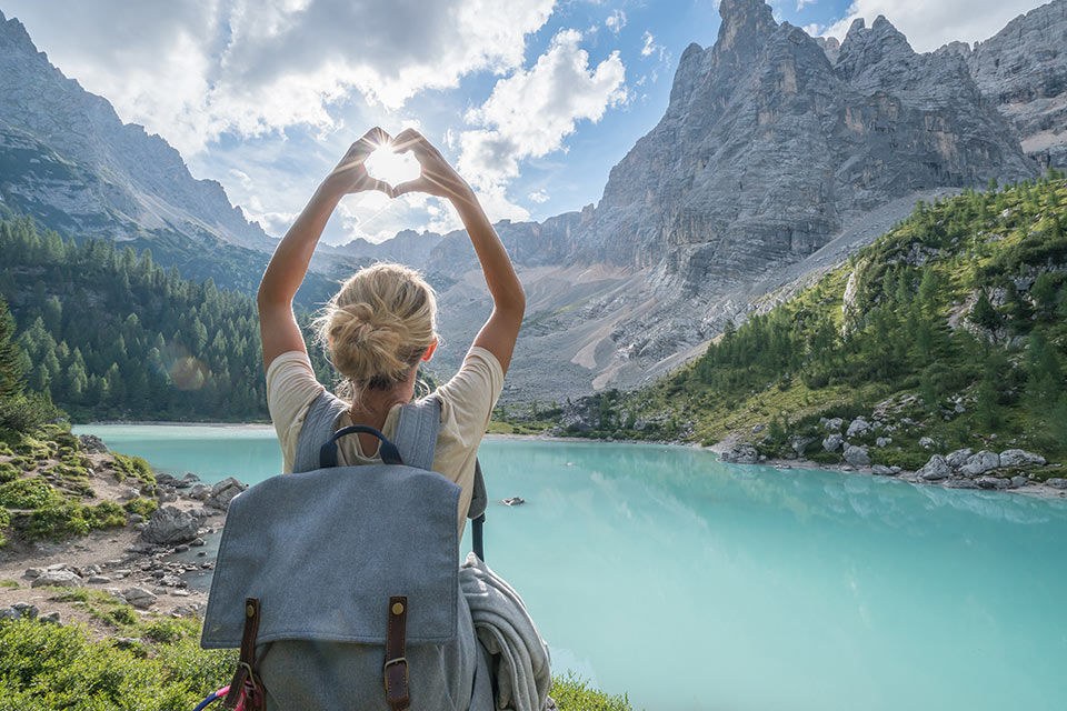 Eine Frau mit Rucksack an einem Bergsee