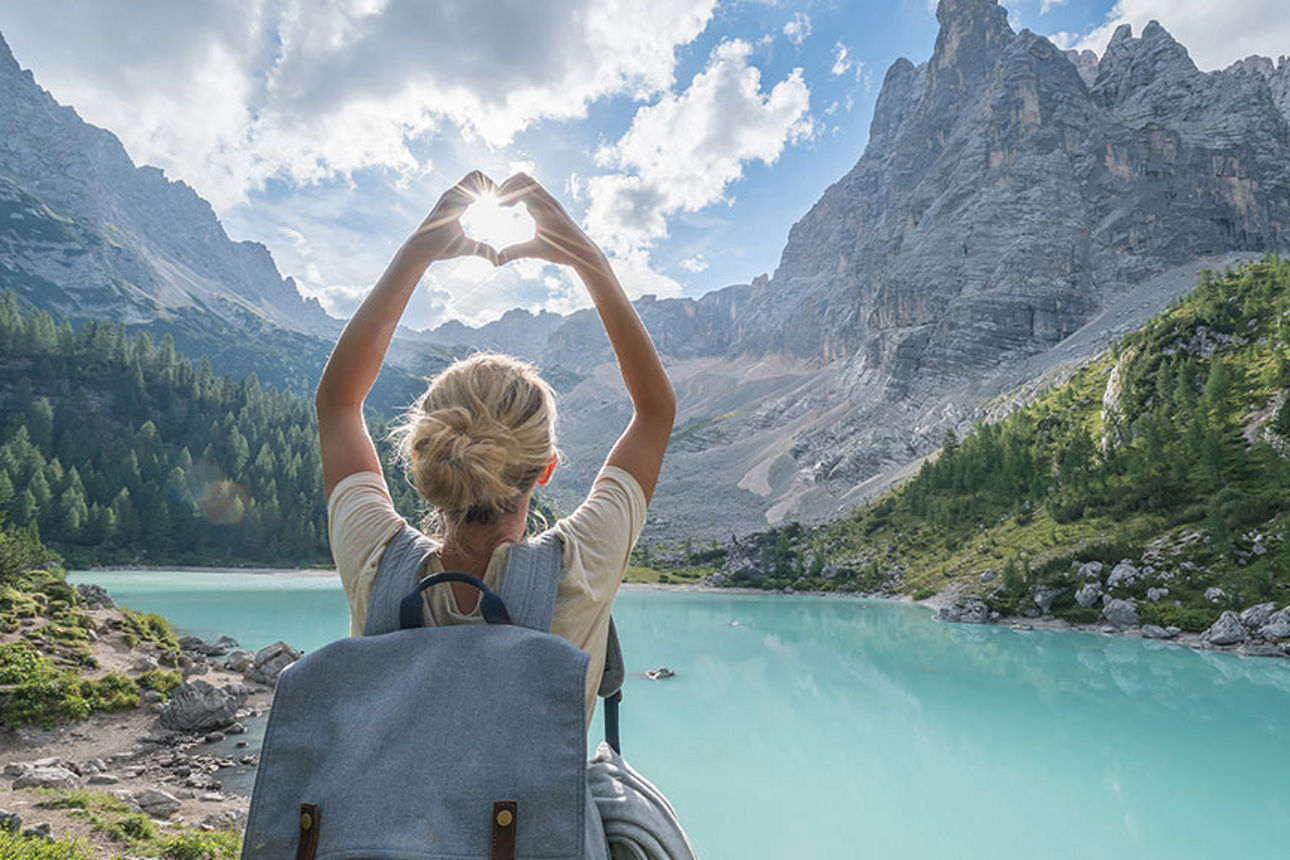 Eine Frau mit Rücksack an einem Bergsee