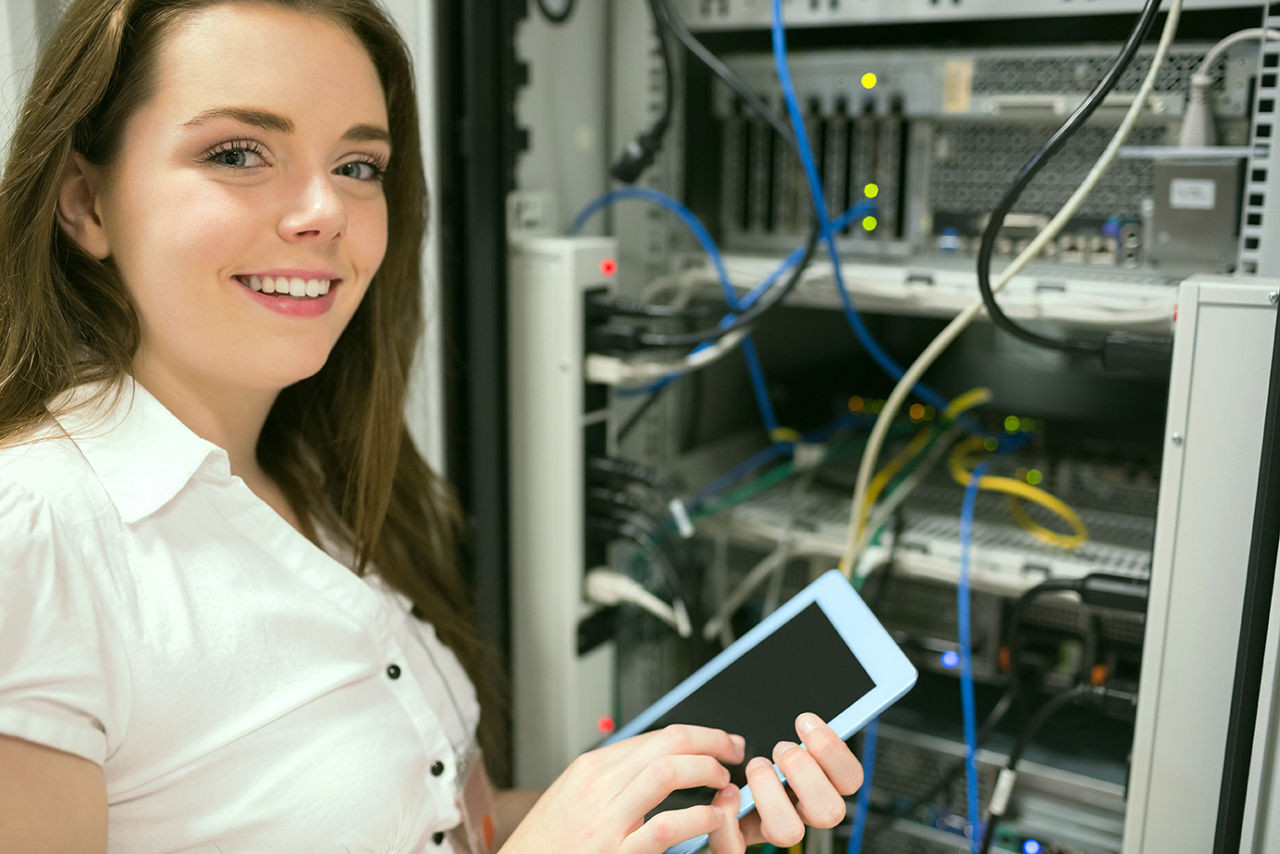 Auszubildende der PSD Bank Rhein-Ruhr mit Tablet vor einem Serverschrank