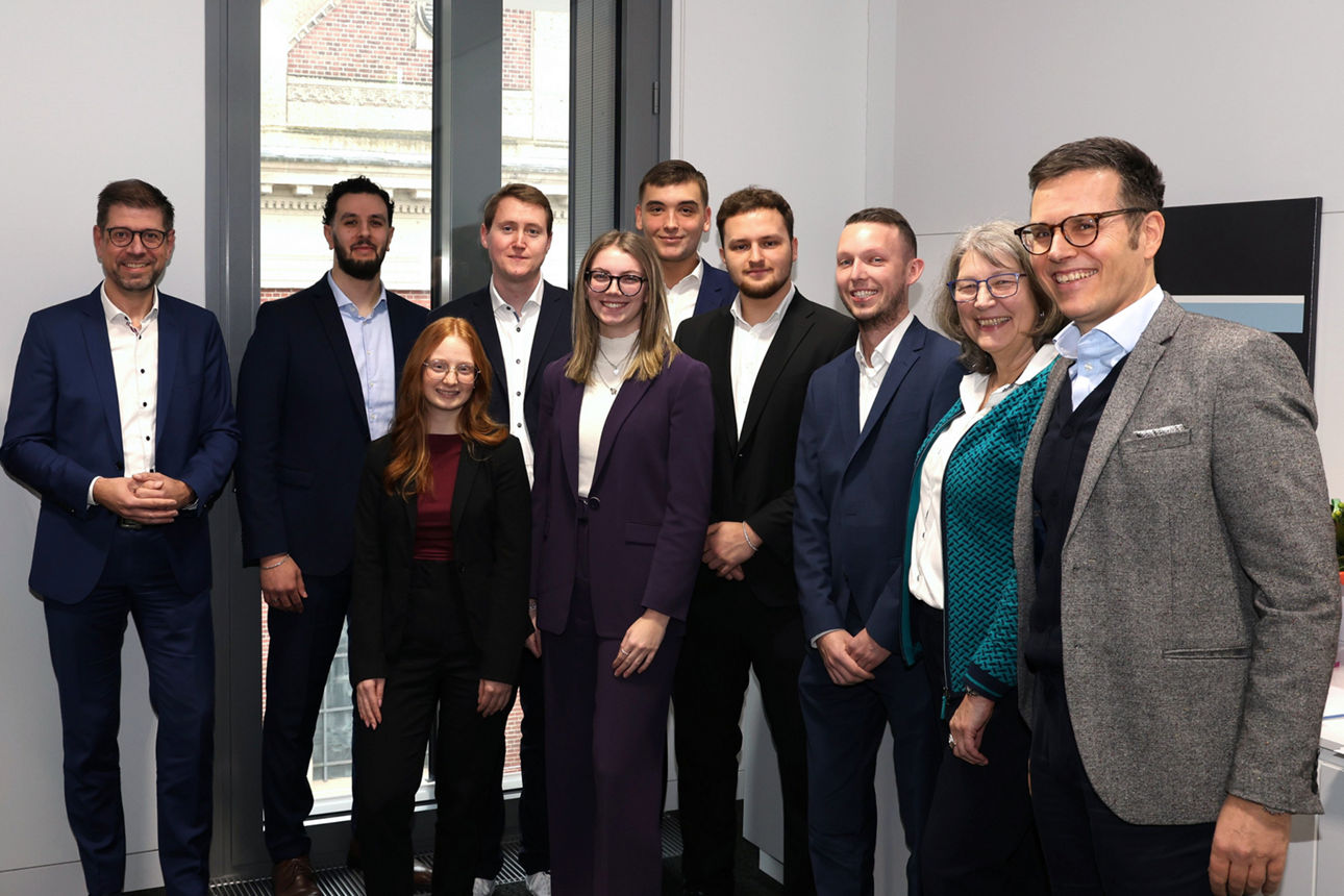 Gruppenfoto von acht frisch ausgelernten Auszubildenden mit Vorständen und Betreuern bei einer Ehrung.