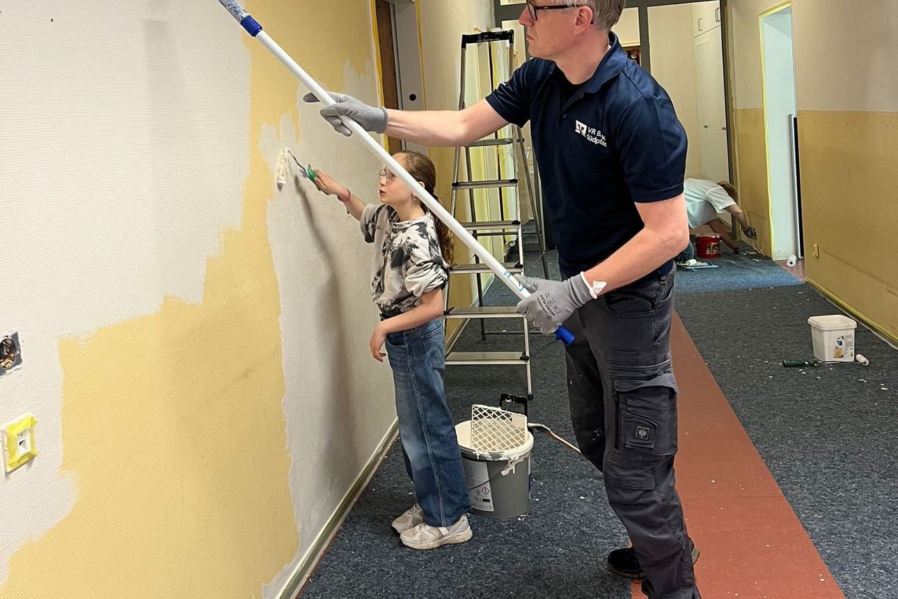 Mann streicht eine Wand weiss