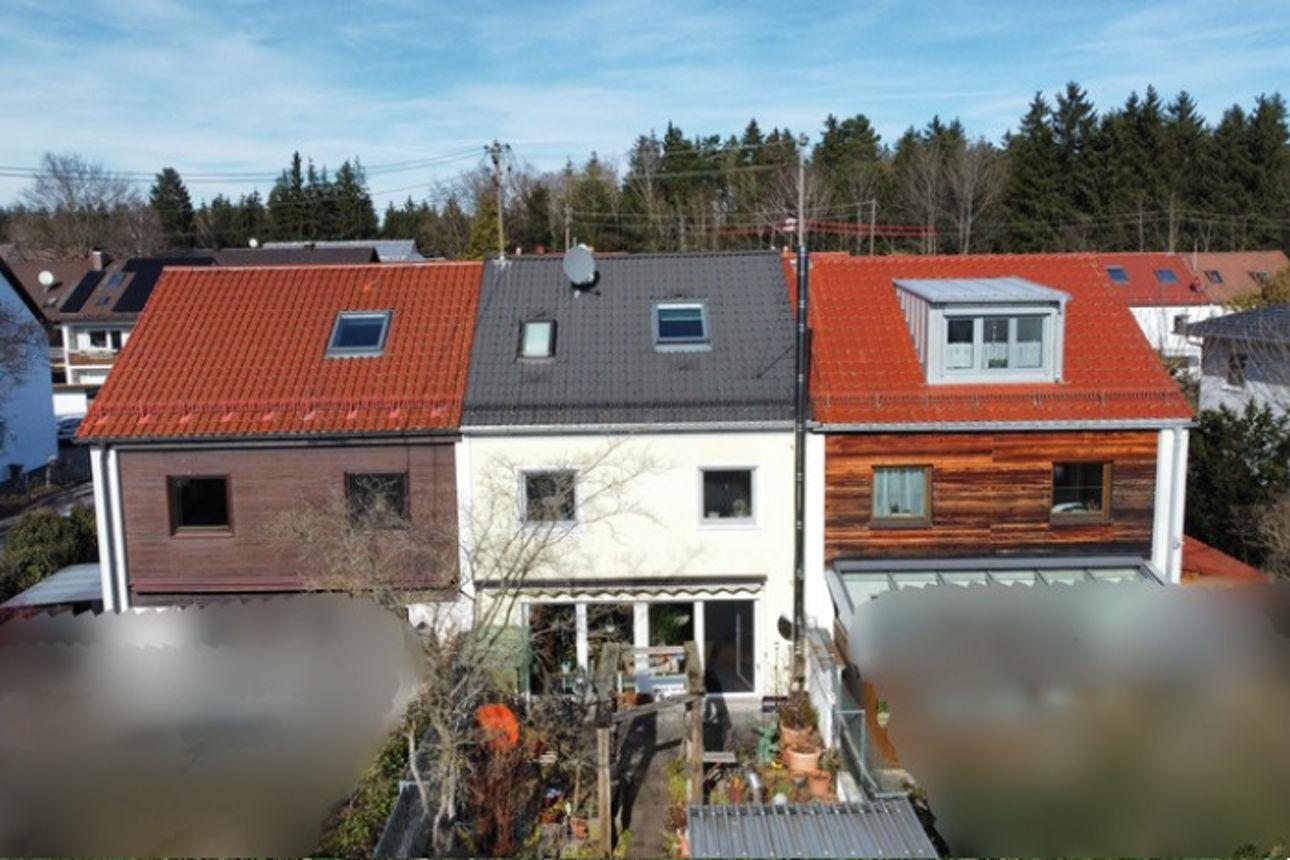 Ein Haus mit rotem Dach und weißen Fenstern.