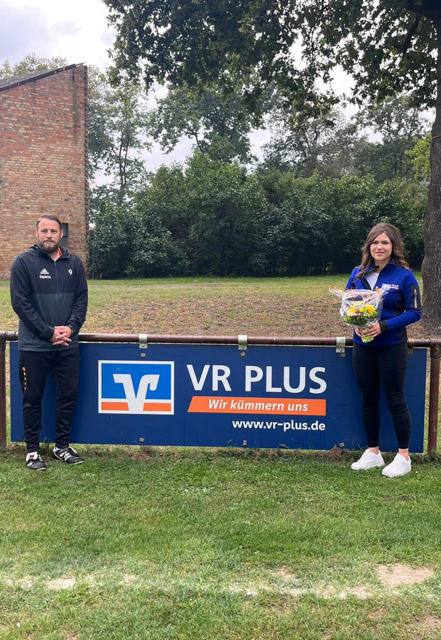 Bandenwerbung beim Rossauer Sportverein SV links von der Werbung steht ein Mann und rechts eine Frau