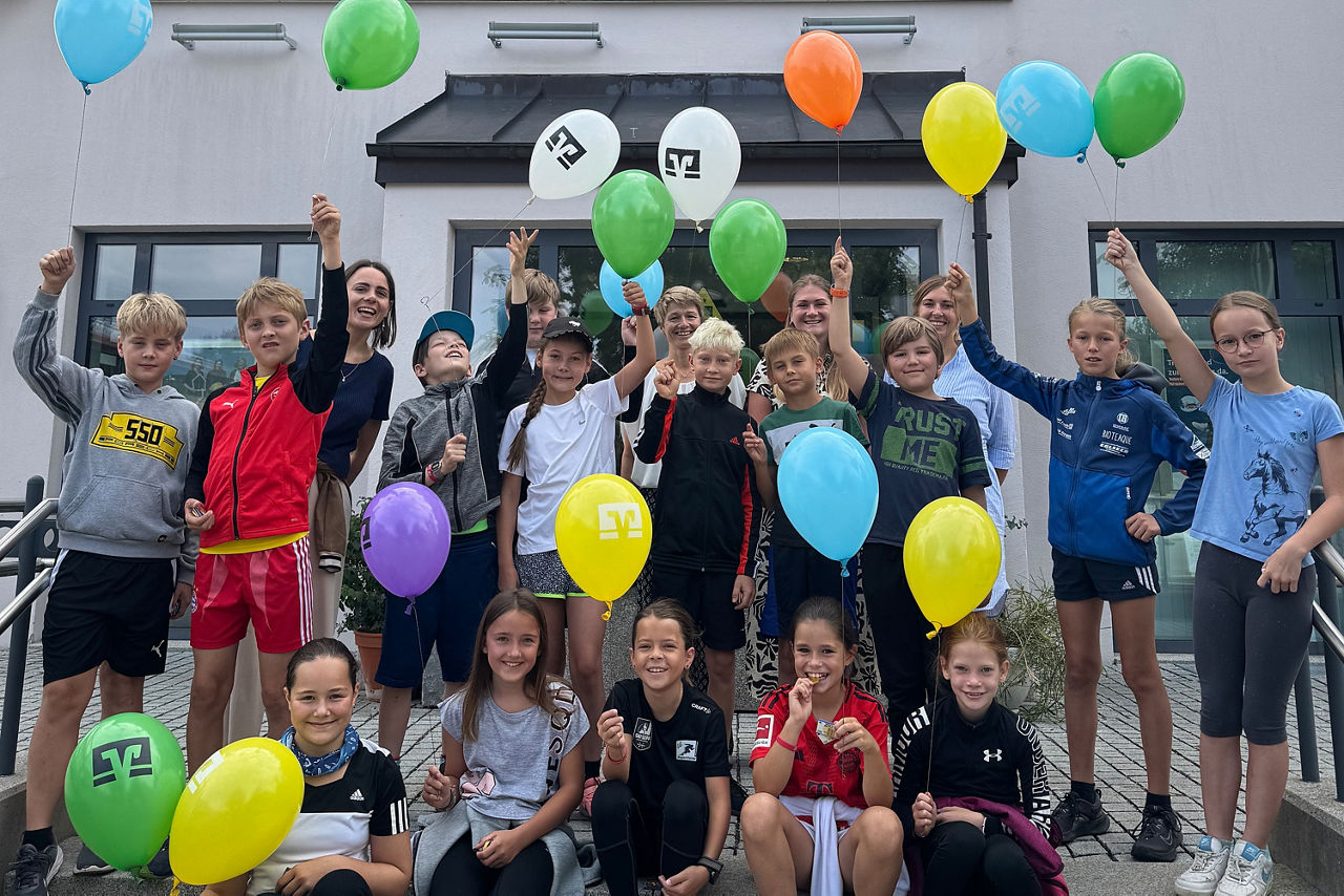 Gruppenfoto von Kindern vor einer Geschäftsstelle. 