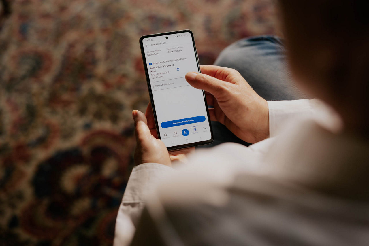 Person vereinbart in der Banking App einen Termin