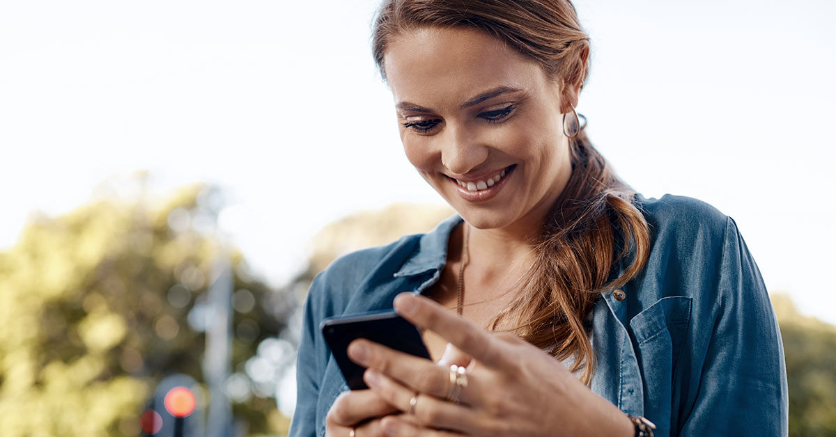 Frau blickt auf das Smartphone in ihrer Hand