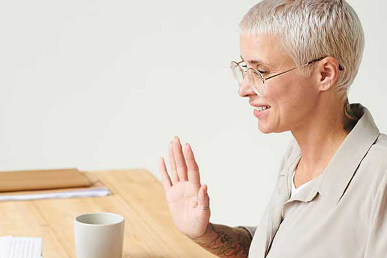 Weitere Informationen - Eine Frau einer Brille sitzt am Schreibtisch