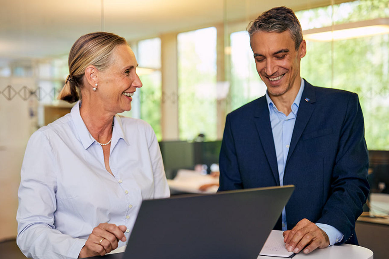 Zwei Personen unterhalten sich mit Laptop
