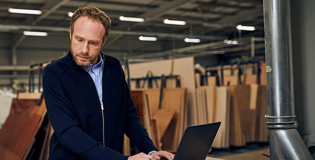 Ein Mann mit Schutzausrüstung bedient Maschinen in einer Fabrik.
