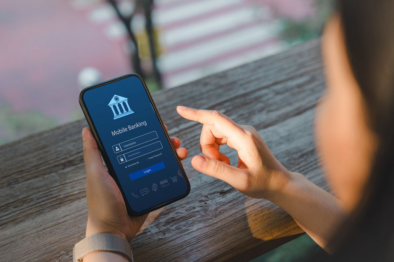 Online-Zahlungskonzept. Blick über die Schulter einer Frau, die auf ihrem Smartphone eine Mobile-Banking-App nutzt und die Ei