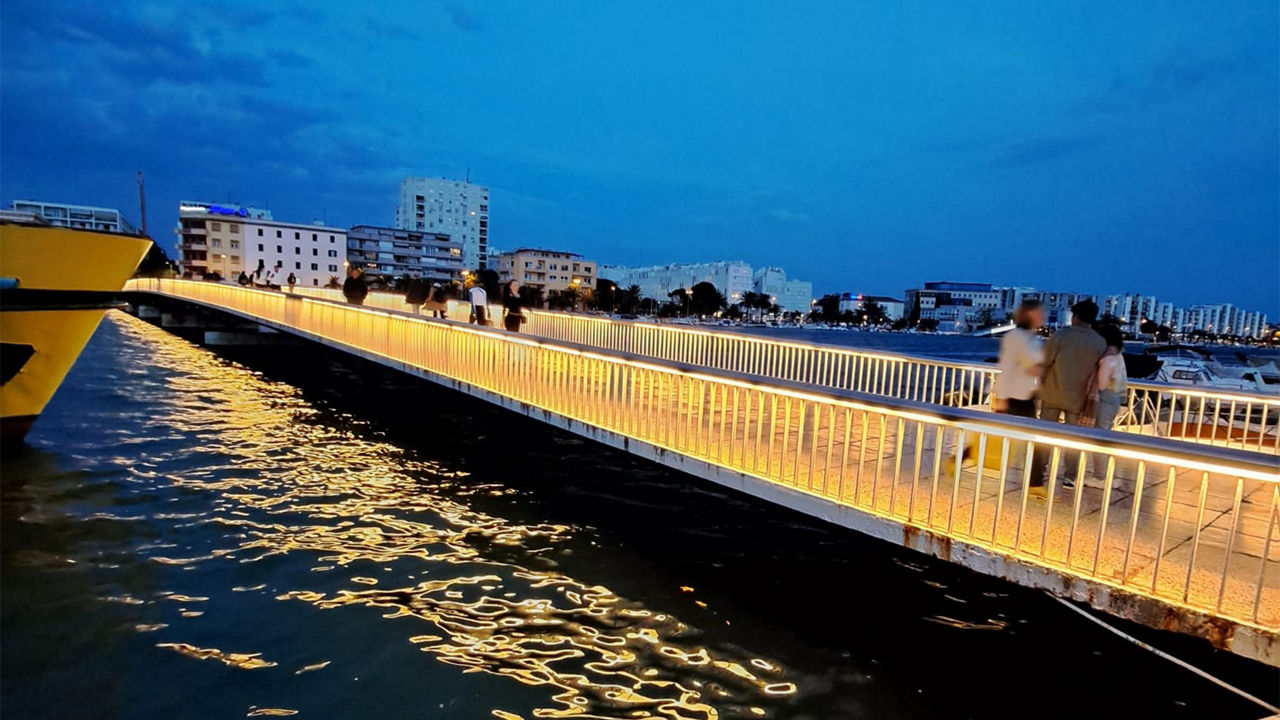 Beleuchtete Brücke über einen großen Fluss während der Dämmerung