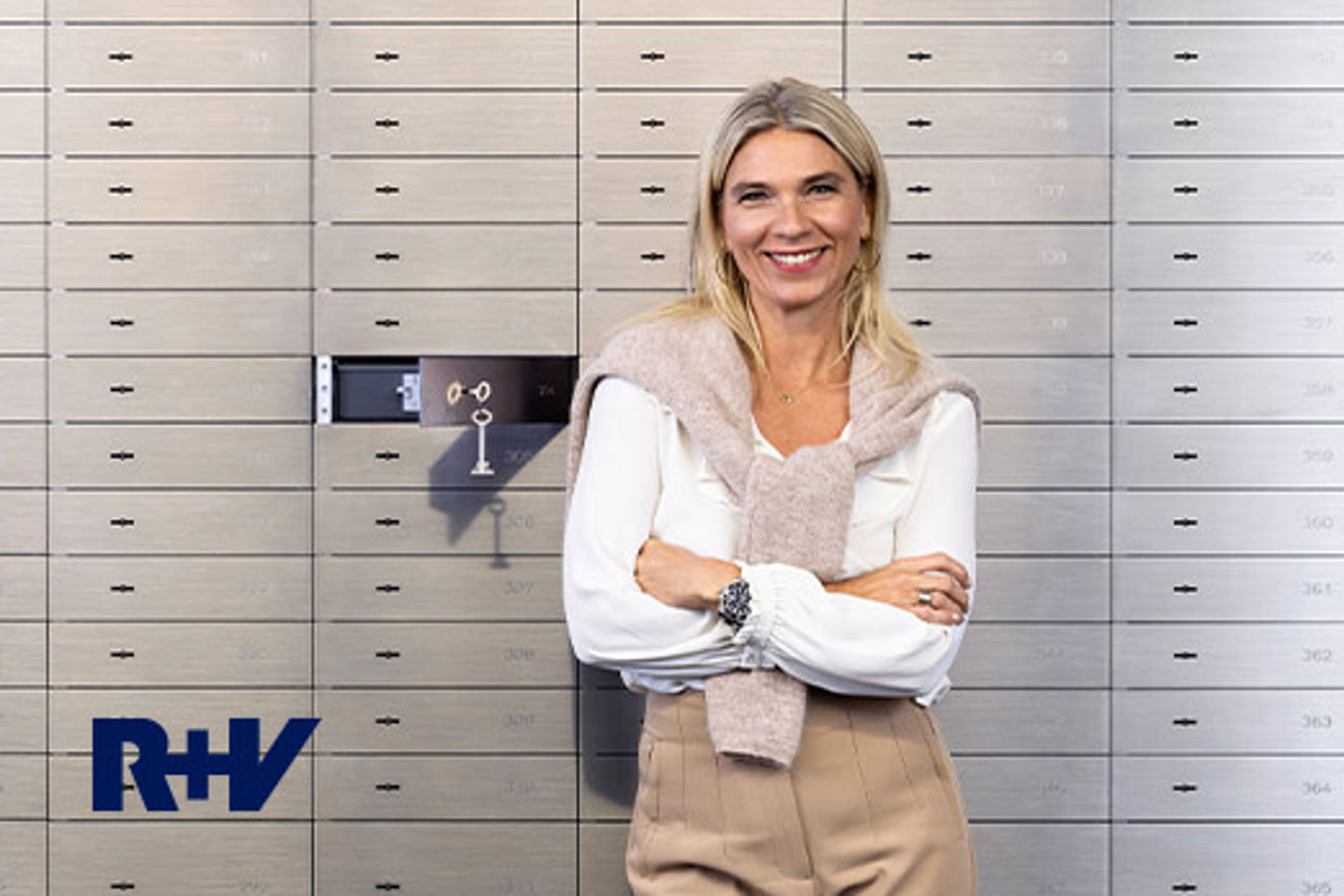 Eine Frau steht vor einer Wand mit Bankschließfächern