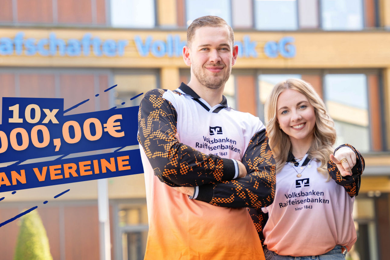 Zwei Personen im Trikot von den Volks-und Raiffeisenbanken. Stehen vor der Hauptstelle der Grafschafter Volksbank.