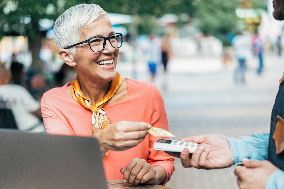 Frau hält girocard an Lesegerät