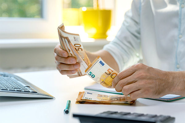 Hände halten Geldscheine in der Hand und zählen diese
