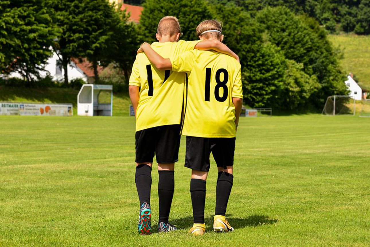 Junge Männer geben sich die Hand beim Tennisspielen