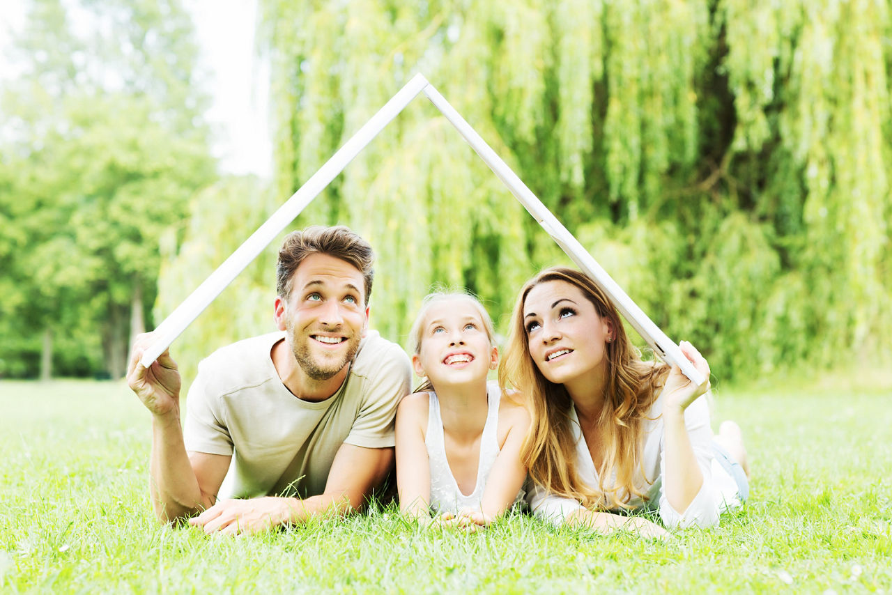Familie mit einem Metermass als Dach über dem Kopf