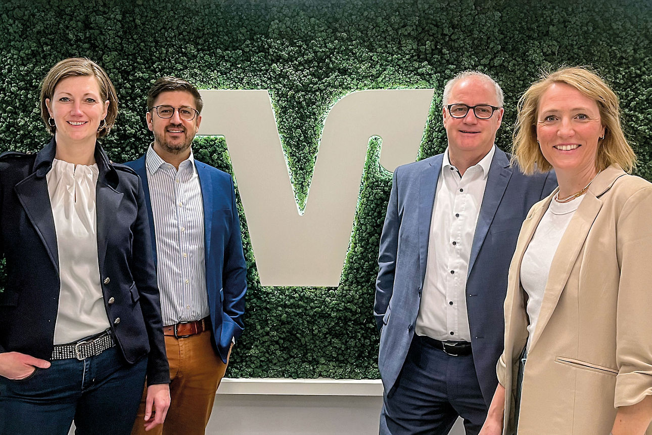 Das Baufinanzierungsteam vor einem grünen Hintergrund. Es sind zwei Frauen und zwei Männer zu sehen.