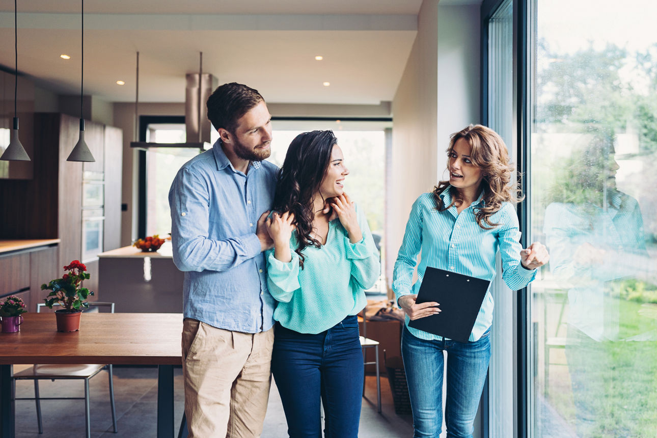 Eine Beraterin spricht mit einem jungen Paar im eigenen Zuhause