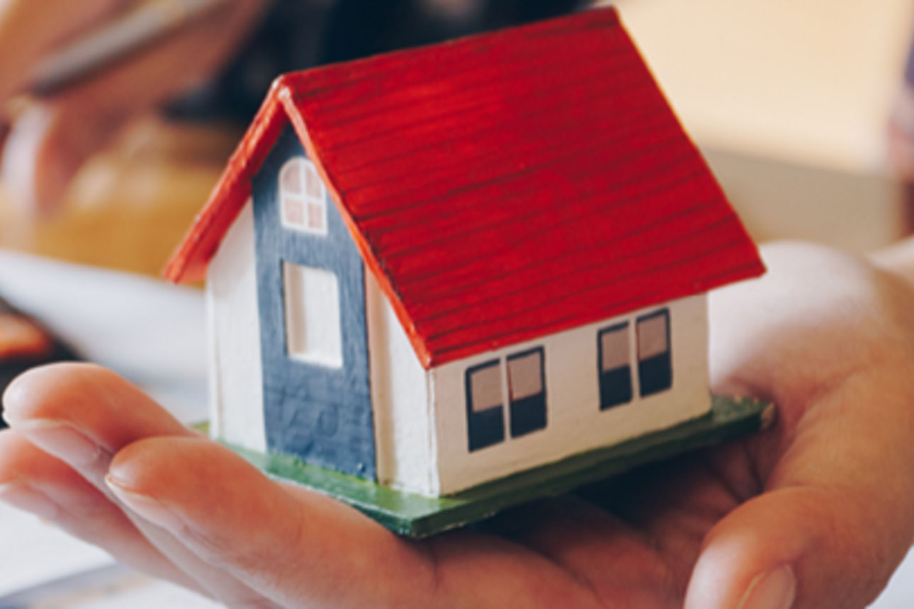 kleines Haus in den Händen eines Mannes