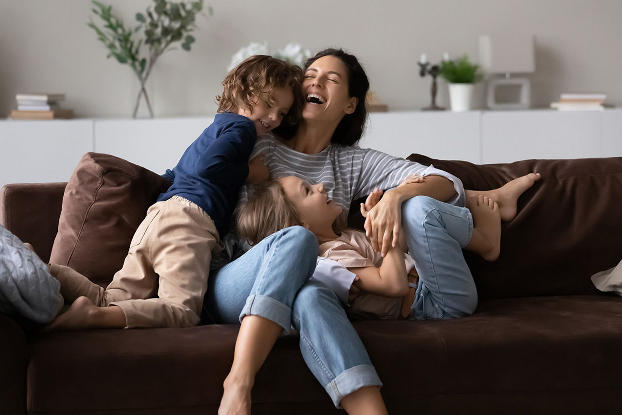Familie sitzt lachend und glücklich auf der Couch