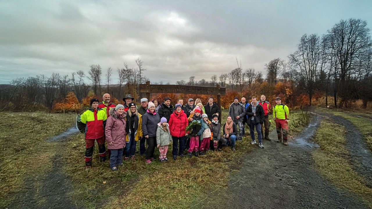 Gruppenfoto aller Helfenden der Baumpflanzaktion im Bürgerwald Ehlscheid vor den Setzlingen auf der freien Fläche