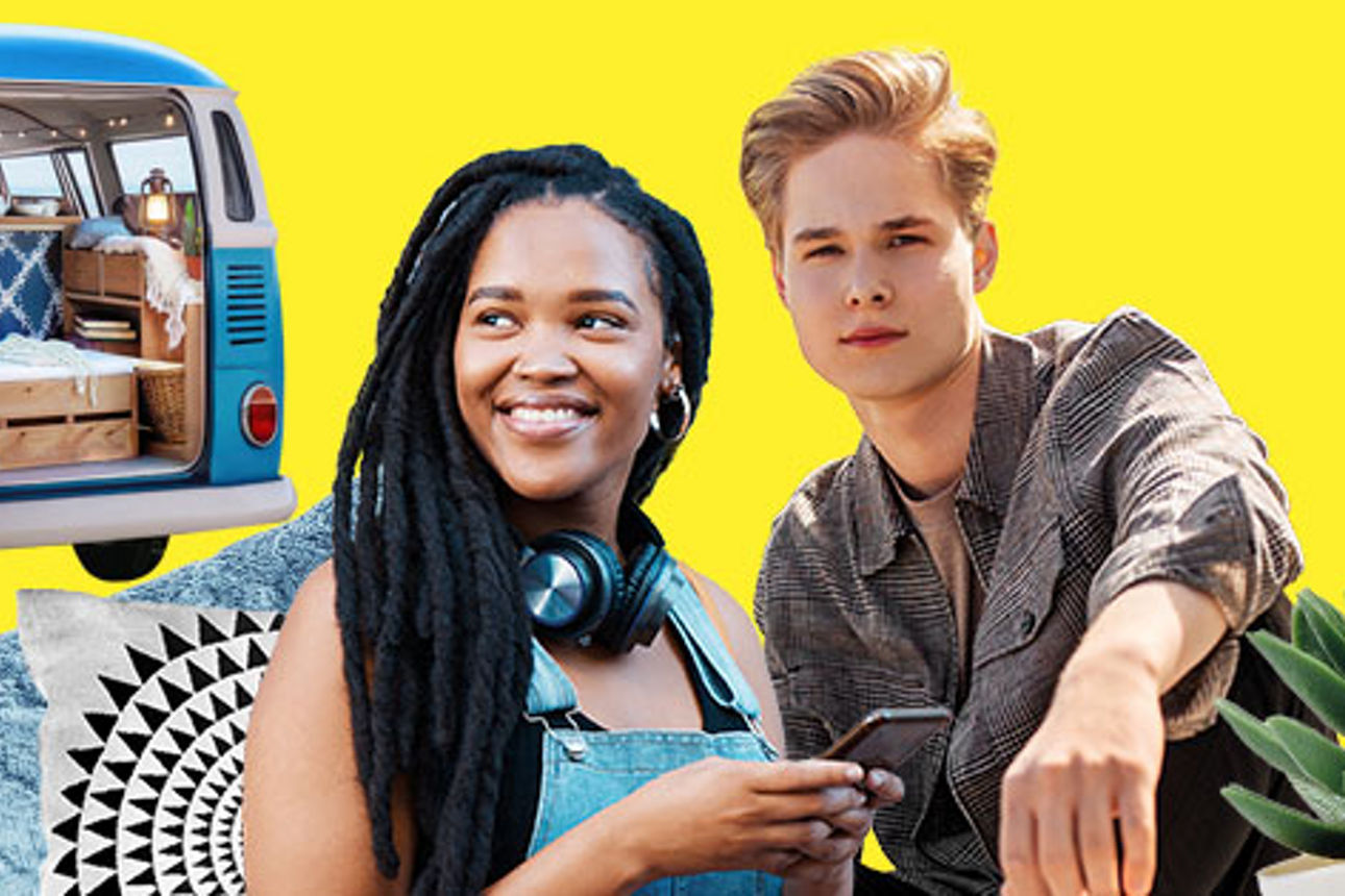 2 junge Kunden mit Handy vor einem Wohnwagen 