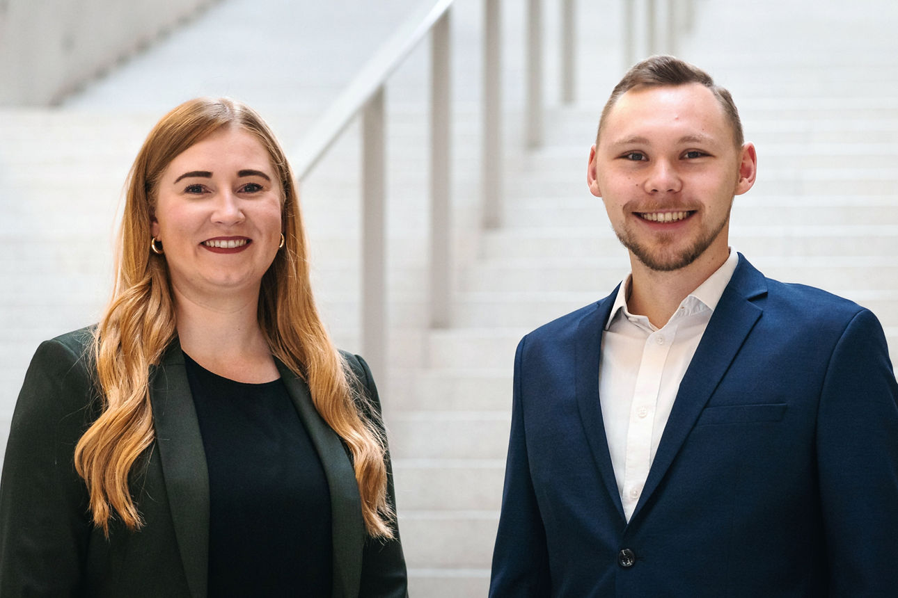 Ein Mann und eine Frau in einer Werkstatt schauen gemeinsam auf ein Tablet