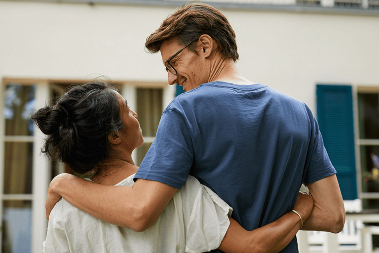 Junges Paar vor hochwertiger Immobilie