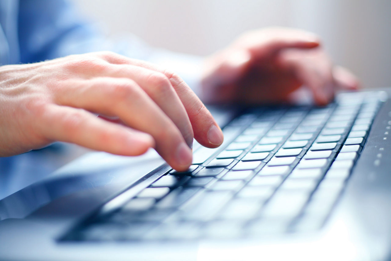 Tippende Hände über einer Computertastatur