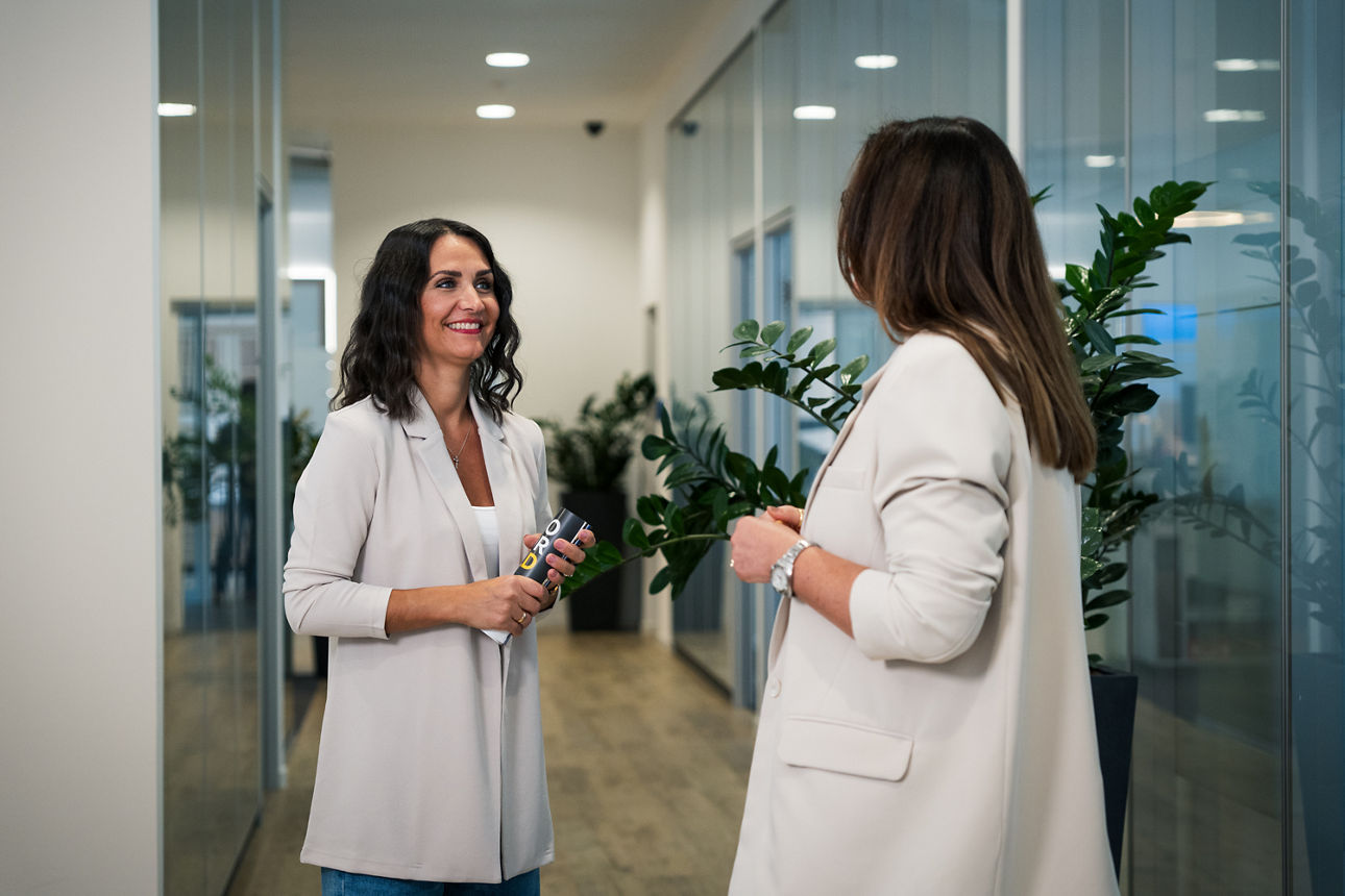 Eine Beraterin steht mit einer Kundin in einer Bankfiliale