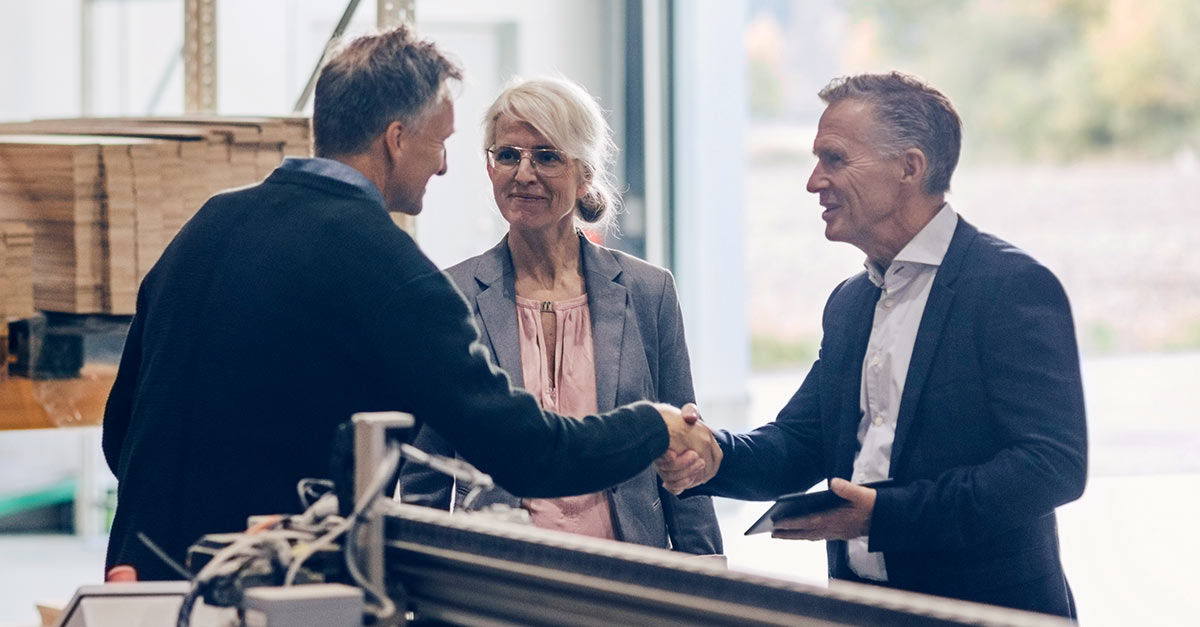 Älterer Mann sitzt lachend auf Landmaschine
