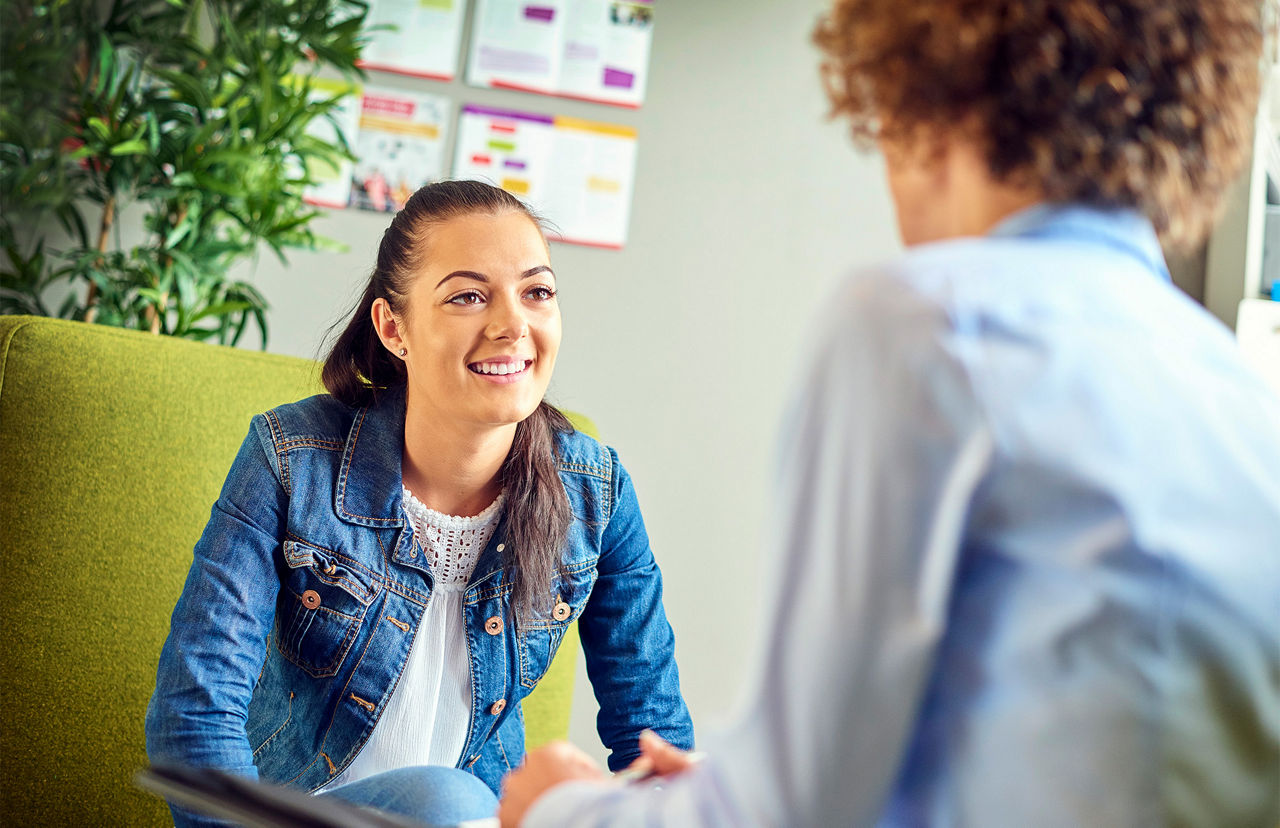 Zwei junge Menschen sitzen an einem Tisch und sind in einem Gespräch vertieft