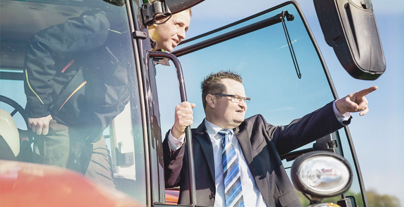 Bankberater zeigt einem Landwirt die Richtung vor