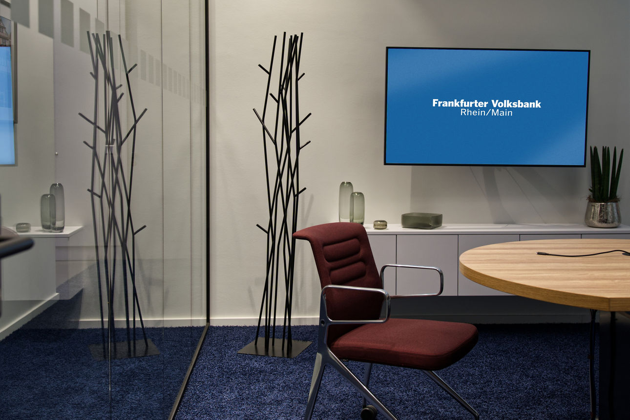 Beratungszimmer einer Filiale der Zukunft mit Fischernetz-Teppich, Glaswand und offenem Konzept