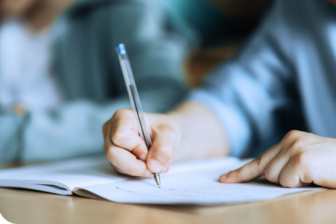 Kind mit einem Stift und einem Heft