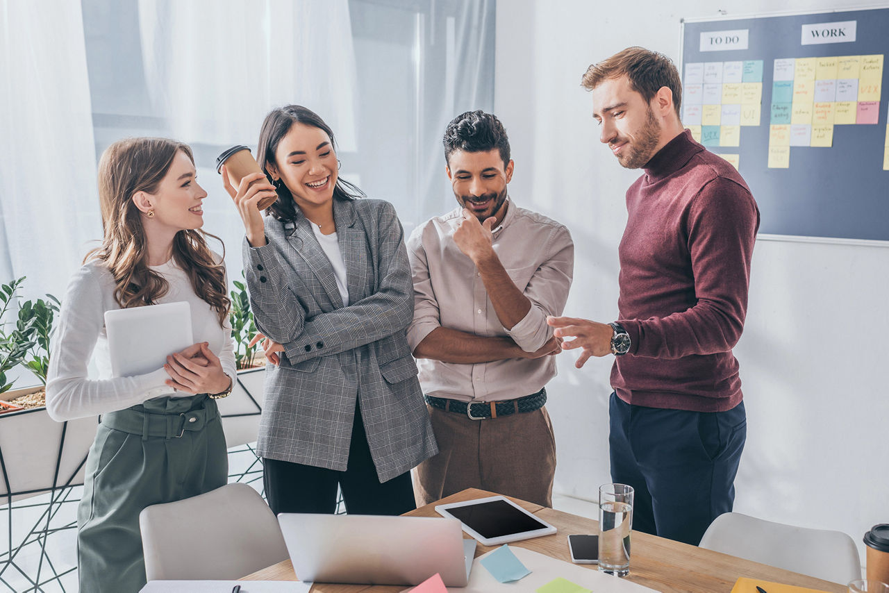 Mehrere Personen stehen in einem Büro bei einer Besprechung