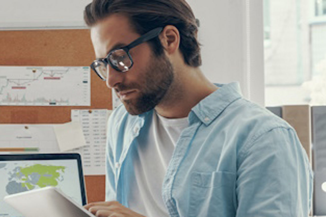Mann arbeitet an einem Tablet-Computer