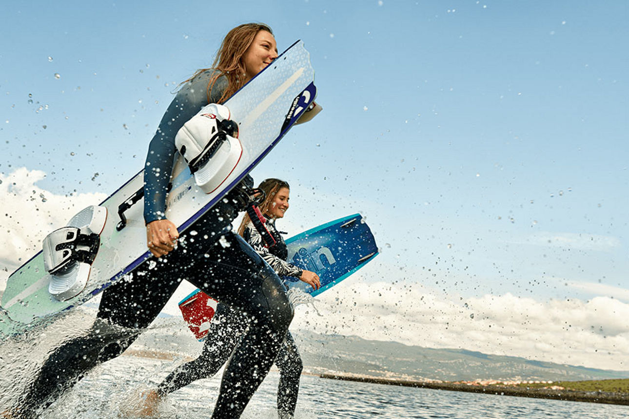 Zwei junge Frauen beim Surfen.