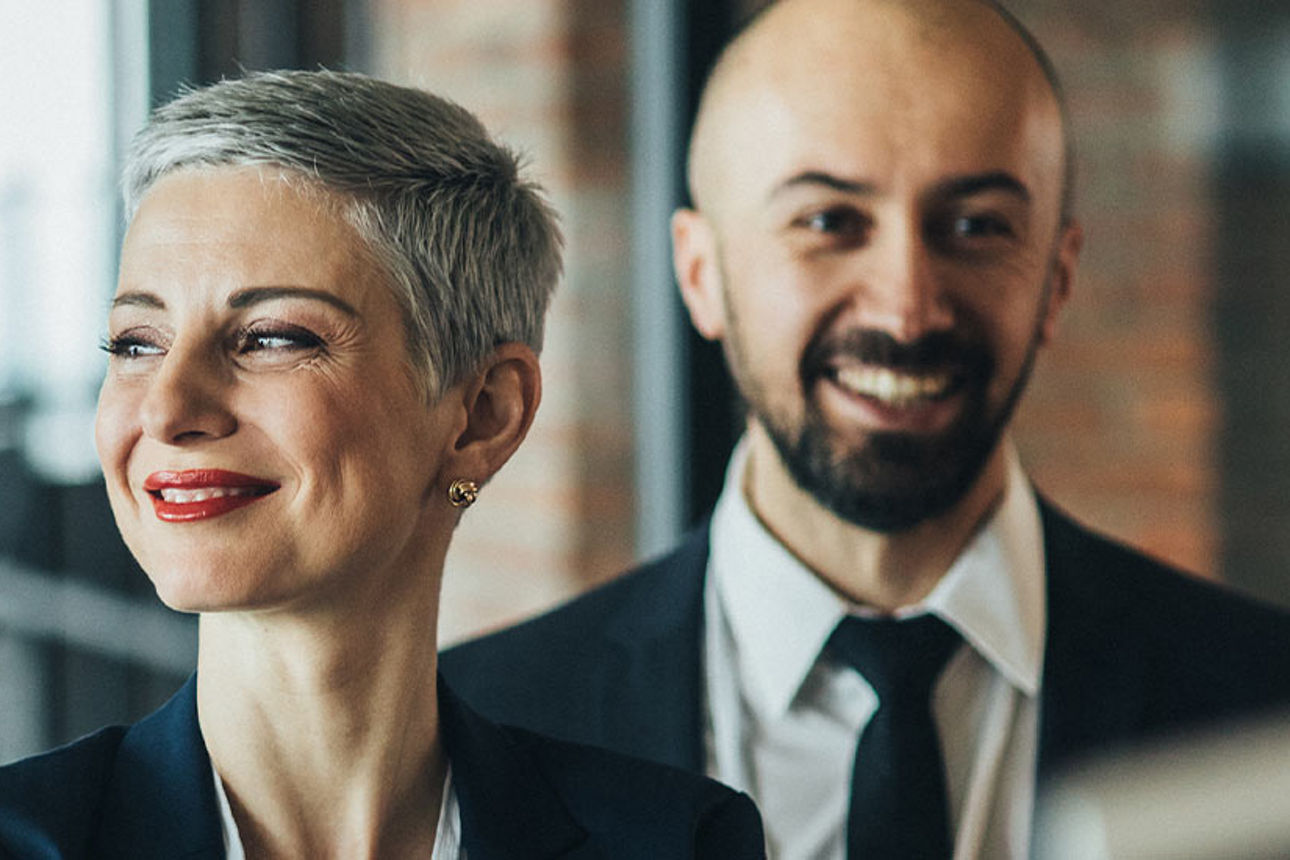 3 Personen in Business Looks schauen zufriden