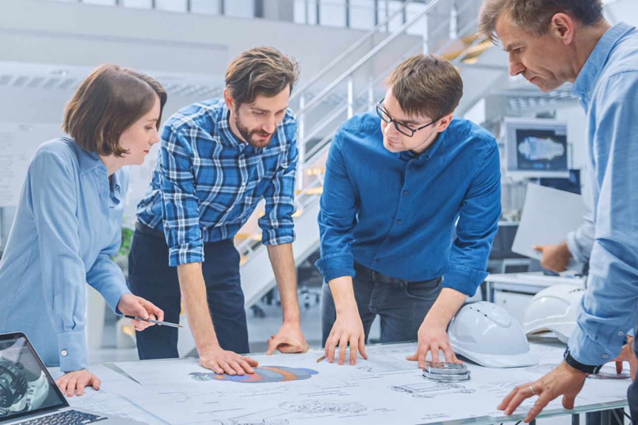 Team in blau gekleidet um Arbeitstisch